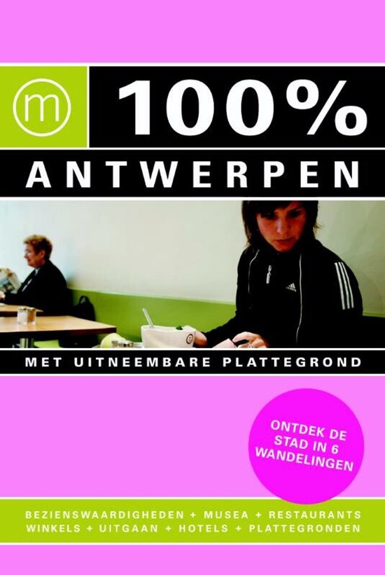 Twee jonge vrouwen zitten in een restaurant met het logo '100% Antwerpen' op de muur.