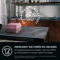 Stapel roze handdoeken op een tafel, met 'APPROVED BY SWISSTEST' logo.