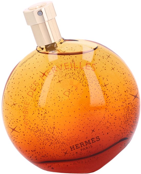 Ronde oranje parfumfles met gouden dop, met sprankelende gouden deeltjes en L'Ambre des Merveilles tekst.