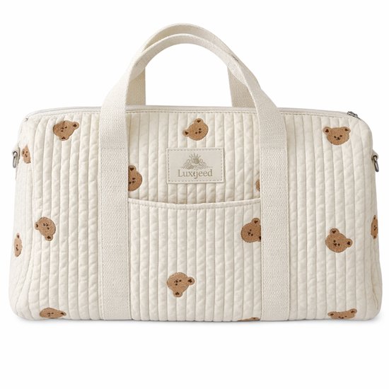 Sac de voyage matelassé blanc cassé avec imprimé ours en peluche, poignées et une étiquette Luxegoed.