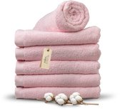 Stapel roze badlakens op een zwarte achtergrond, met een label 'Miss Towels' en takjes katoen.