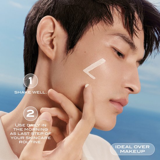 Man brengt Lancaster Sun Perfect AIR crème aan op zijn gezicht. Tekst: "Ideaal over make-up".