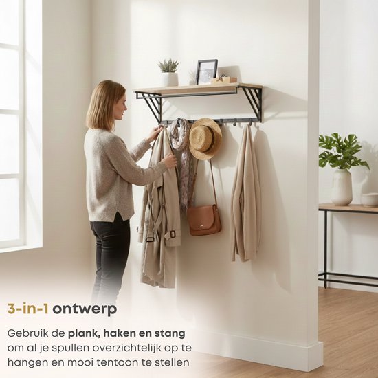 Een vrouw hangt een jas aan een wandkapstok met houten plank, kledingstang en 7 haken.