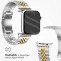 Zilveren en gouden horlogebandje, "Selencia", en "Stainless Steel" met een detail van de bevestiging aan een Apple Watch.
