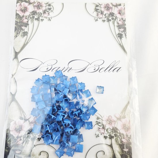 Een pakje met blauwe vierkante studs, met het BamBella logo en bloemendecoratie op de achtergrond.