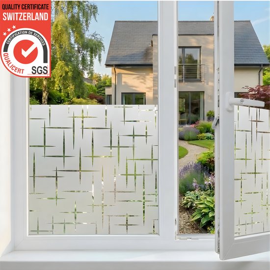 Raamfolie met geometrisch patroon op een raam met uitzicht op een tuin en huis