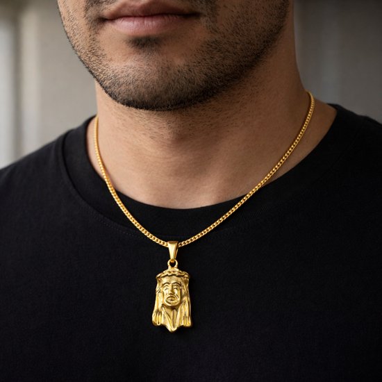 Gouden hanger met Jezus-figuur, gedragen door een man met een zwart shirt.