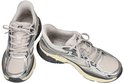 Twee zilverkleurige Skechers Slip-ins sneakers met mesh panelen, donkerblauwe accenten en een crèmekleurige zool.
