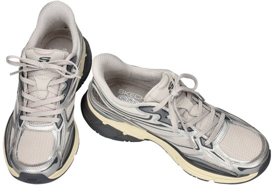 Twee zilverkleurige Skechers Slip-ins sneakers met mesh panelen, donkerblauwe accenten en een crèmekleurige zool.