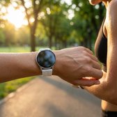 Wit smartwatch met wit siliconen bandje om de pols van een vrouw na het sporten, met zweetdruppels.