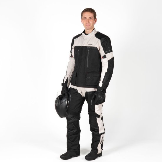 Man in zwart/lichtgrijs motorjack en -broek, met helm en handschoenen.