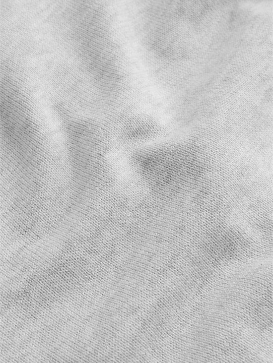 Close-up van de gebreide stof van een lichtgrijs babyvestje.
