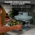 Grijze Ninja airfryer op een aanrecht, met een glazen bak met broccoliroosjes. Vrouw houdt de bak vast. Tekst: Dagelijks koken en opnieuw krokant maken.