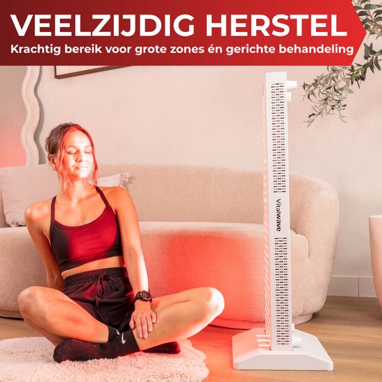 Vrouw mediteert zittend voor een staand rood lichttherapiepaneel in een woonkamer.