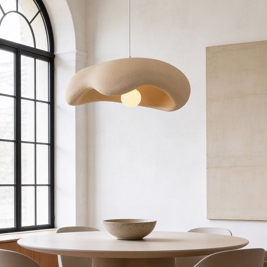 Lampe suspendue Wabi Sabi beige sable de forme organique, suspendue au-dessus d'une table à manger ronde.