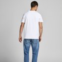 Man met zijn rug naar de camera, draagt een wit Jack & Jones t-shirt en blauwe jeans.