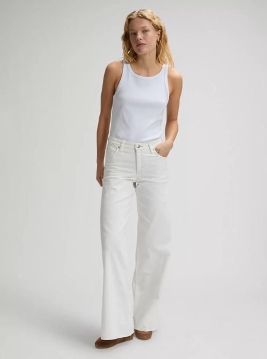 Vrouw met witte wijde jeans en een lichte blauwe top.