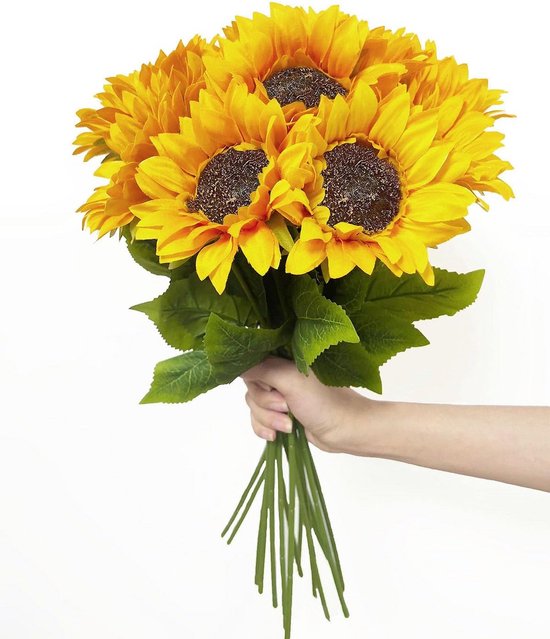  Bouquet de tournesols artificiels, pétales jaunes, centres bruns, feuilles vertes, tenu dans une main.