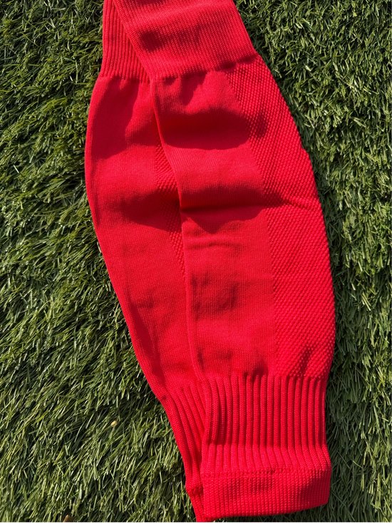 Heldere rode voetbalsleeves met reliëf textuur en brede ribbelboord.