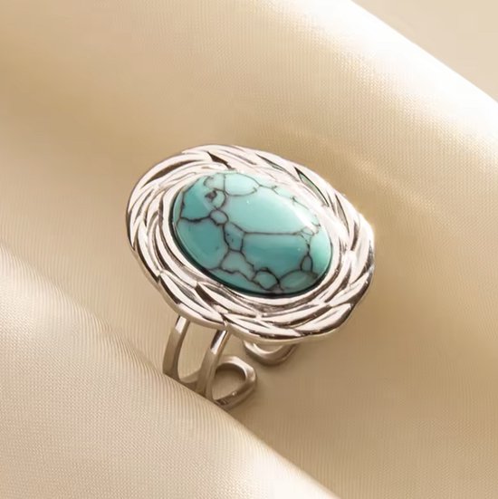 Bague argentée avec une pierre précieuse turquoise ovale bleu clair aux veines noires. La bague est ajustable.