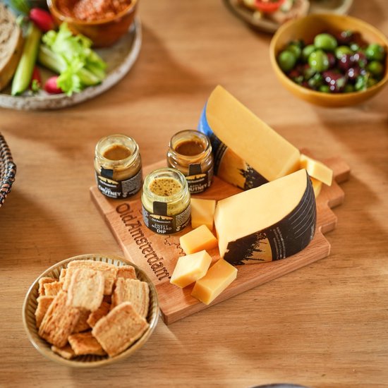 Houten kaasplank met drie potjes Old Amsterdam dips, kaasblokjes, kaasstukken en crackers.