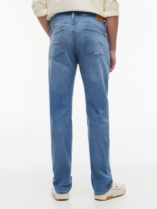 Achterkant van een blauwe jeans met lichte wassing, gedragen door een man.