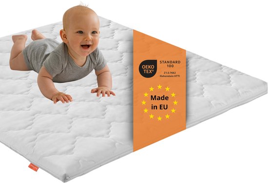 Baby op een wit matras met keurmerk 'Made in EU' en OEKO-TEX.