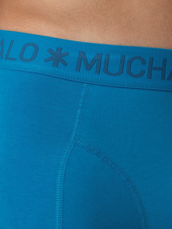 Close-up van de blauwe Muchachomalo boxershort met focus op de tailleband met logo en stiksels.