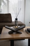 Donkerbruine eikenhouten boekenstandaard op een houten salontafel.