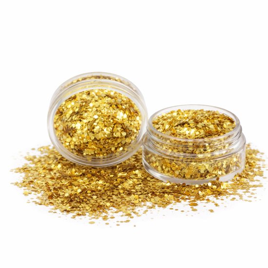 Twee potjes met gouden chunky glitters, omringd door losse glitters op een witte achtergrond.