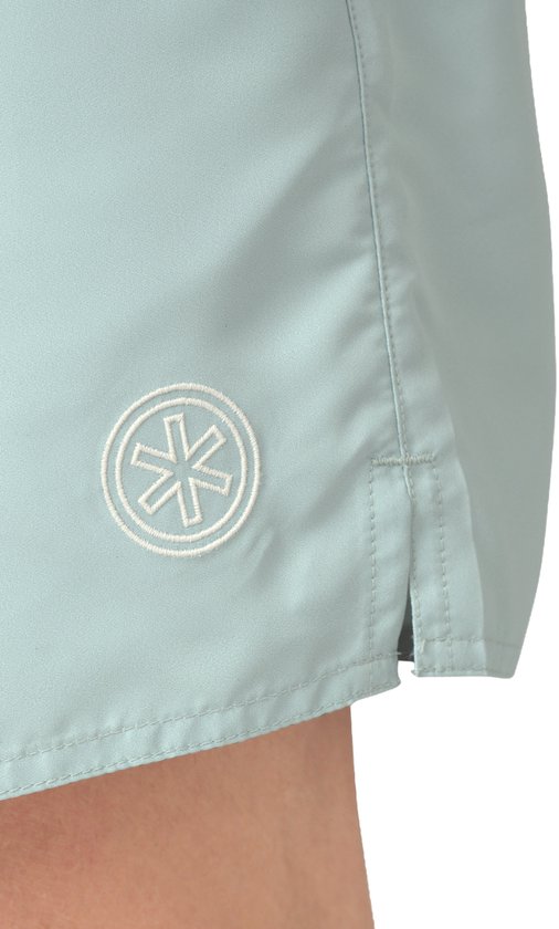 Lichtblauwe zwembroek met logo cirkel op de zijkant en split aan de zoom.