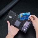 Open zwarte portemonnee met een creditcard erin en een fotoplaatje. Details van stiksels en vakken.