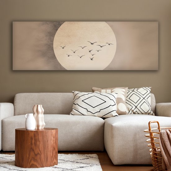 Een langwerpig canvas met een grote, licht beige cirkel tegen een beige achtergrond. Een groepje donkere vogels vliegt in formatie voor de cirkel.