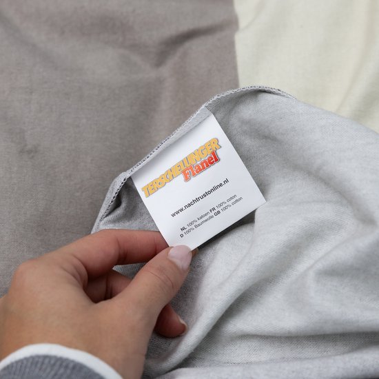 Hand die een label vasthoudt met 'Terschellinger Flanel' en website.