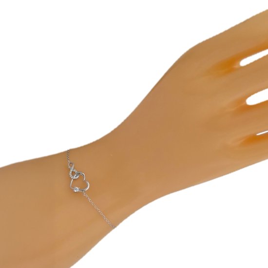 Zilveren armband met infinity hartje op een mannequin hand.