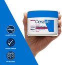 Hand met witte CeraVe pot Intensieve Moisturising Cream. Blauwe dop, tekst 'Fragrance Free', 'Hypoallergeen', 'pH-Neutraal'.