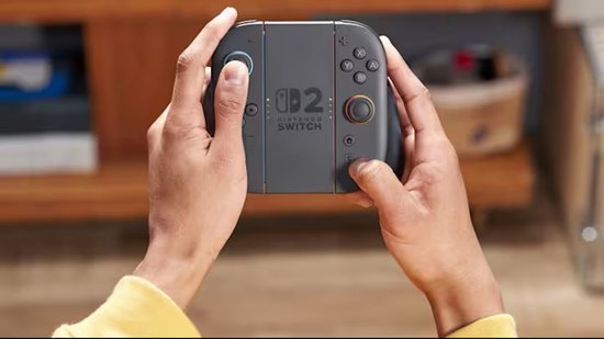 Handen houden een Nintendo Switch 2 Joy-Con controller set vast, met de logo's op de controllers.