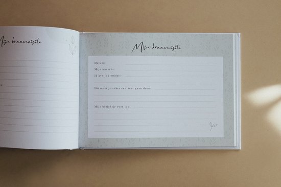 Een open kraamvisiteboek met een zachtgroene achtergrond en botanische print. De rechterpagina bevat het formulier 'Mijn kraamvisite'.