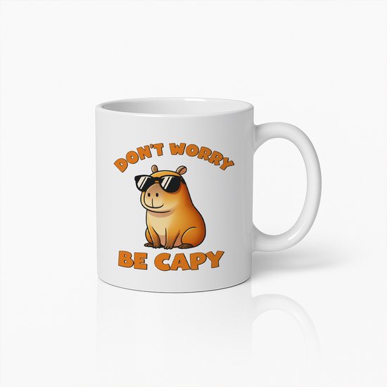 Tasse blanche avec un capybara orange portant des lunettes de soleil. Texte : "DON'T WORRY BE CAPY".