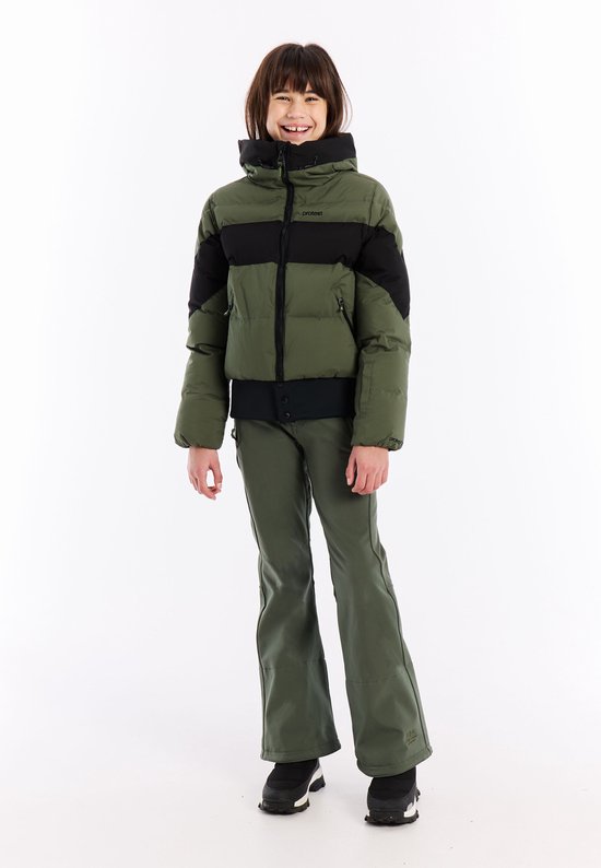 Meisje in groene pufferjas met zwarte banden en groene skibroek.