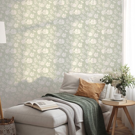 Behang met een lichtgroene achtergrond en een wit bloemenpatroon.
