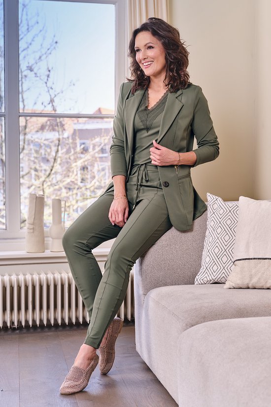 Model in een donkergroene pantalon met hoge taille en trekkoord.
