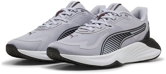 Paar lichtgrijze Puma sportschoenen met zwarte en witte accenten. Horizontale streepdetails op de zijkant.
