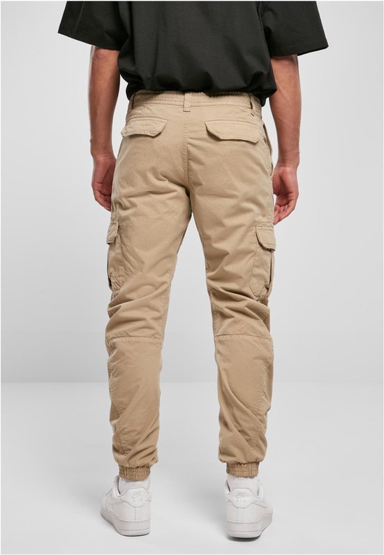 Man met beige cargo broek, achterkant zichtbaar, met zakken en elastische enkelbanden.
