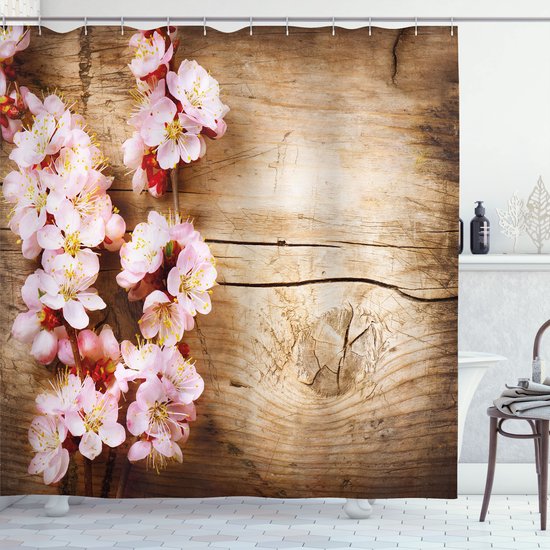 Branches de fleurs de cerisier roses sur fond de bois rustique.