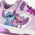 Close-up van lichtpaarse sneakers met Stitch en Angel print. Met klittenbandsluiting en paarse veters.