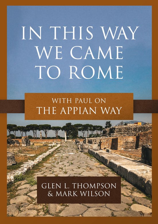 Boekcover met de titel 'IN THIS WAY WE CAME TO ROME' en 'WITH PAUL ON THE APPIAN WAY'. Onder de titel een foto van de antieke Via Appia in Rome.