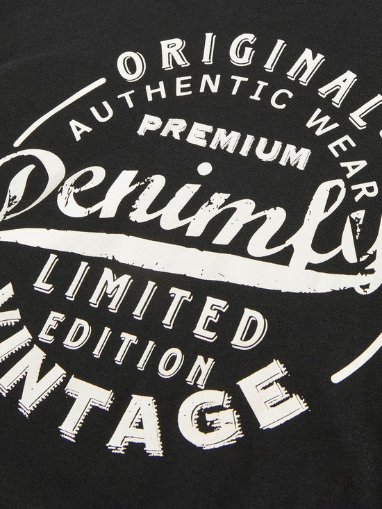 Detail van een zwart T-shirt met ronde opdruk "ORIGINAL AUTHENTIC WEAR PREMIUM Denîmfly LIMITED EDITION VINTAGE"
