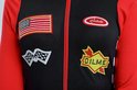 Zwarte en rode racesuit met Amerikaanse vlag patch en 'Jake's' en 'Dilme' patches.