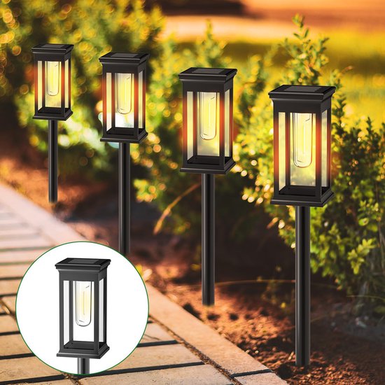 Vier zwarte solar tuinlampen met een rechthoekige, glazen kap en een zichtbare lichtbron. Ze staan langs een tuinpad.